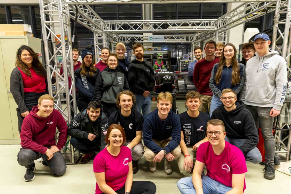 Group of students posing in front of a Formula Student Race Car